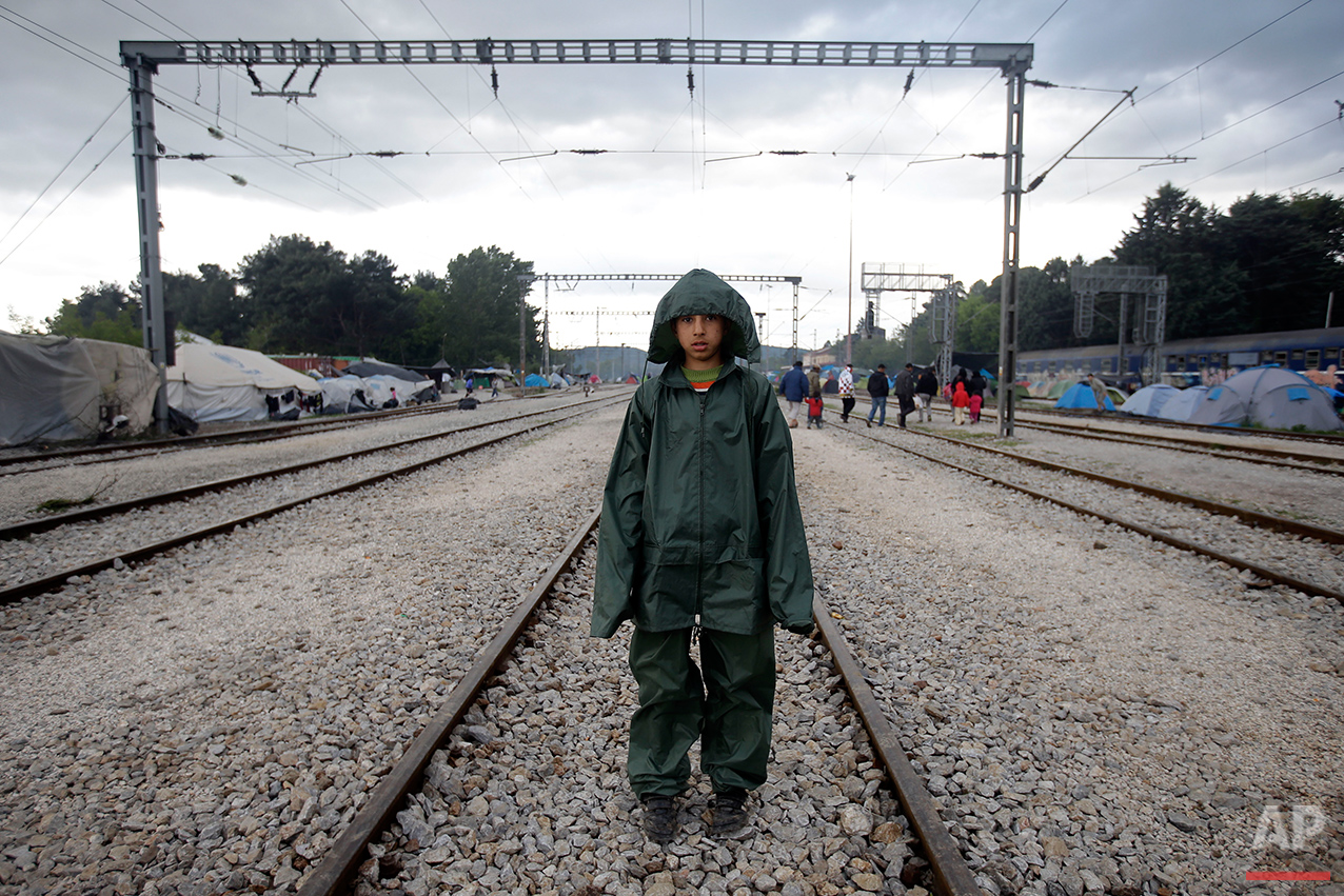  Rostani, 10, from Afghanistan, wears a rain jacket and trousers as he poses for a portrait on the tracks of a rail way station which was turned into a makeshift camp crowded by migrants and refugees at the northern Greek border point of Idomeni, Gre