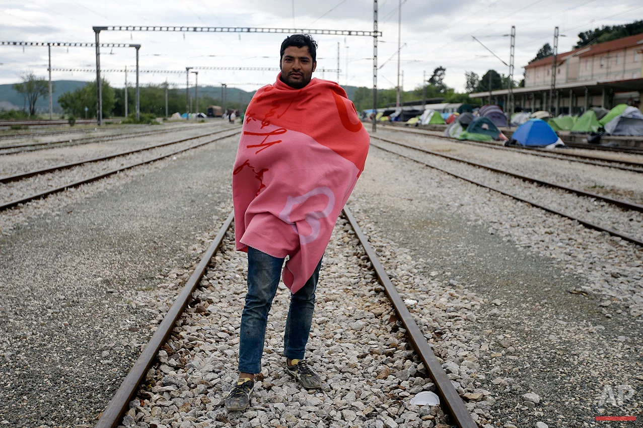 Maleem Sadiq from Pakistan, poses for a portrait on the tracks of a rail way station which was turned into a makeshift camp crowded by migrants and refugees at the northern Greek border point of Idomeni, Greece, Tuesday, May 3, 2016. Many thousands of migrants remain at the Greek border with Macedonia, hoping that the border crossing will reopen, allowing them to move north into central Europe. (AP Photo/Gregorio Borgia)