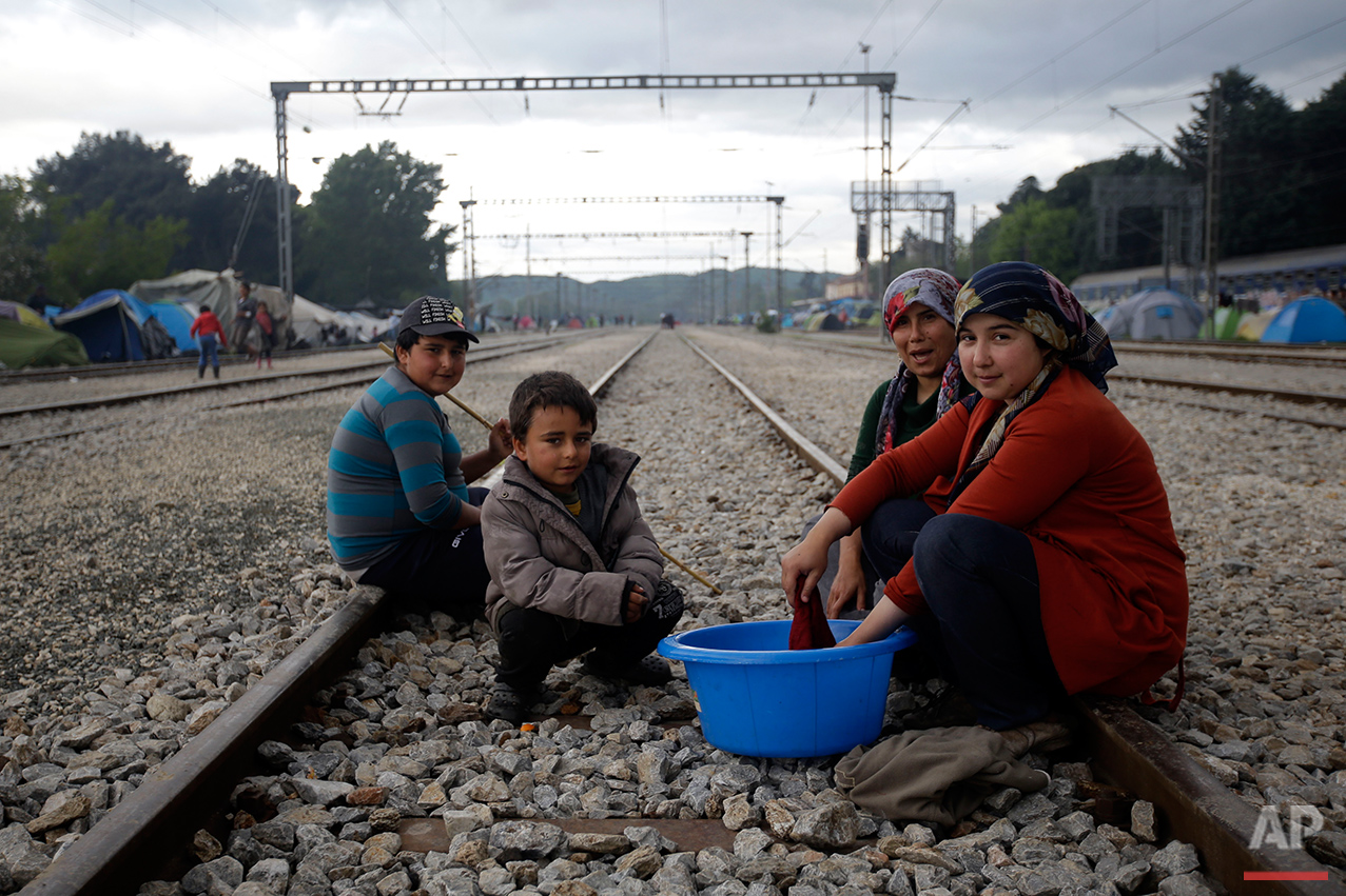  From left, Hames Juma, Mustafa Juma, Fidam Mamu and Susan Ali, all from Syria,  pose for a portrait on the tracks of a rail way station which was turned into a makeshift camp crowded by migrants and refugees at the northern Greek border point of Ido