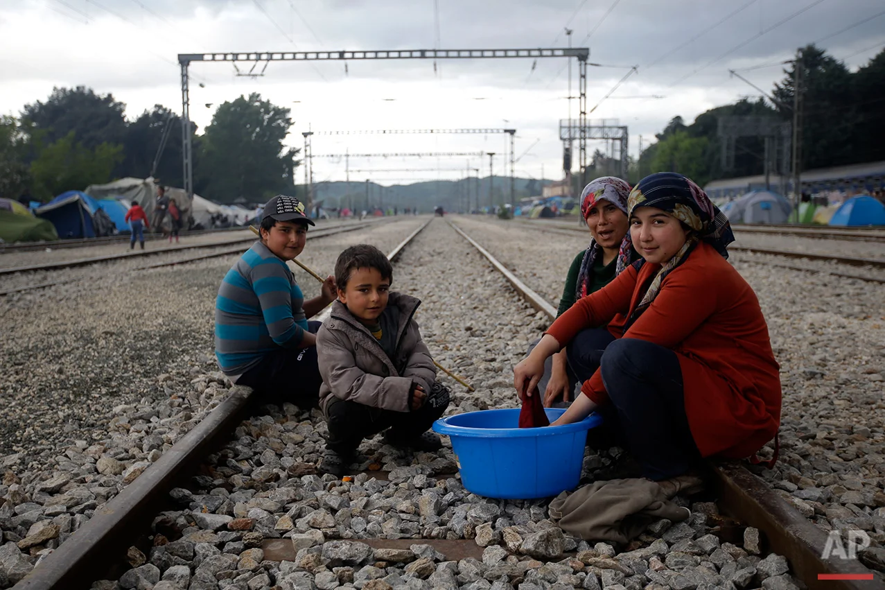 From left, Hames Juma, Mustafa Juma, Fidam Mamu and Susan Ali, all from Syria, pose for a portrait on the tracks of a rail way station which was turned into a makeshift camp crowded by migrants and refugees at the northern Greek border point of Idomeni, Greece, Tuesday, May 3, 2016. (AP Photo/Gregorio Borgia)