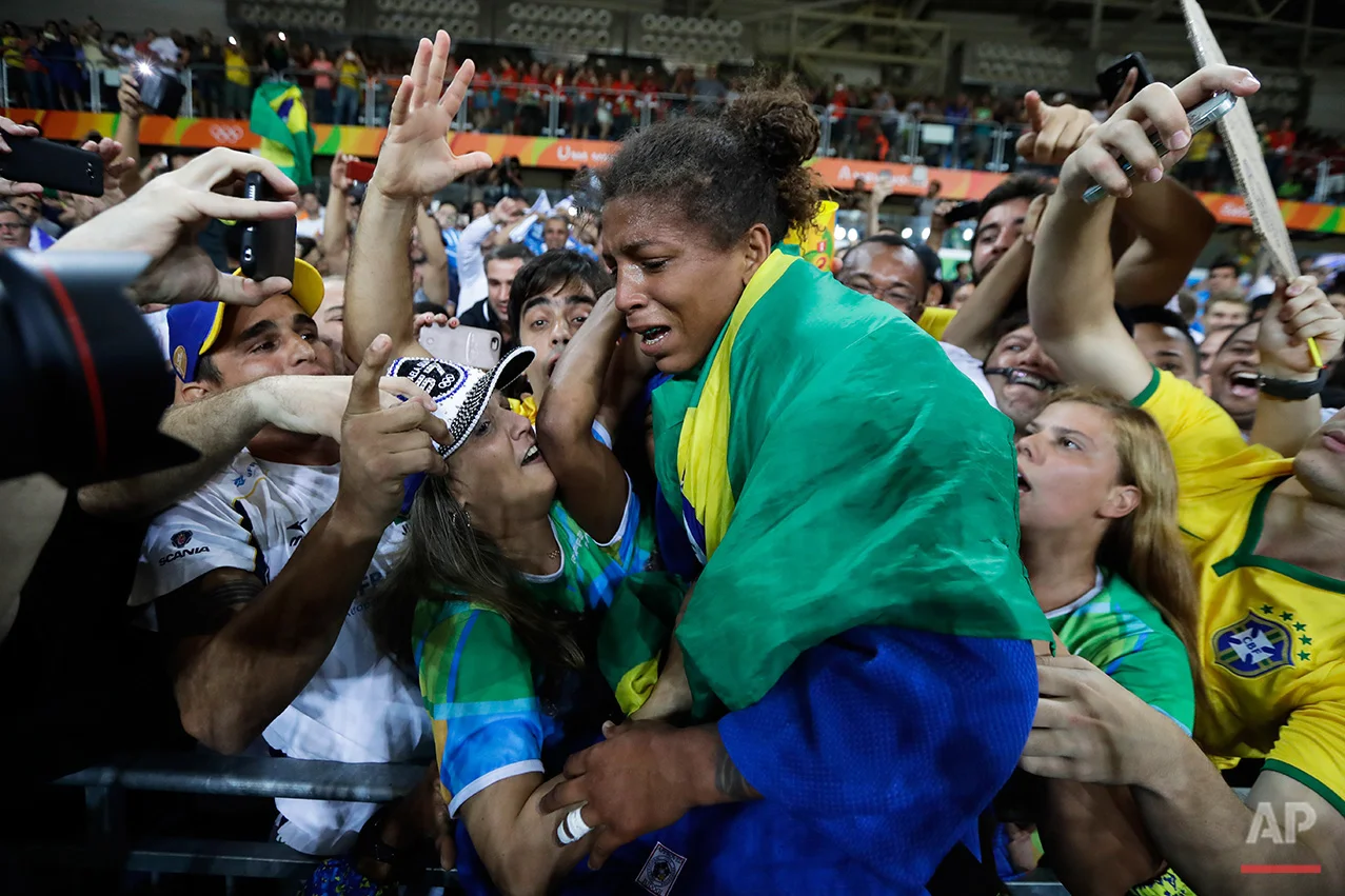 In this Aug. 8, 2016 photo, Brazil's Rafaela Silva, centre, celebrates after winning the gold medal of the women's 57-kg judo competition at the 2016 Summer Olympics in Rio de Janeiro, Brazil. (AP Photo/Markus Schreiber) 