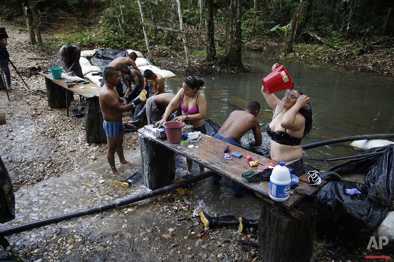  In this Thursday, Aug. 11, 2016 photo, rebels of the 48th Front of the Revolutionary Armed Forces of Colombia, or FARC, wash their clothes and bathe in a creek near their hidden camp in the southern jungles of Putumayo, Colombia. The rebels were get