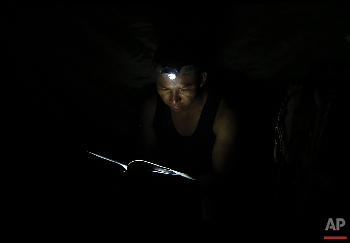 In this Aug. 11, 2016 photo, a rebel soldier of the 48th Front of the Revolutionary Armed Forces of Colombia, or FARC, uses a head lamp to for some late-night reading at a FARC encampment in the southern jungles of Putumayo, Colombia. The soldier is