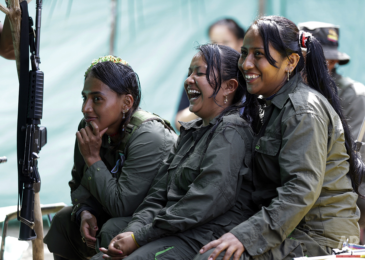  In this Aug. 11, 2016 photo, rebels of the 32nd Front of the Revolutionary Armed Forces of Colombia, or FARC, laugh during a break, at their camp in the southern jungles of Putumayo, Colombia. As Colombia's half-century conflict winds down, with the