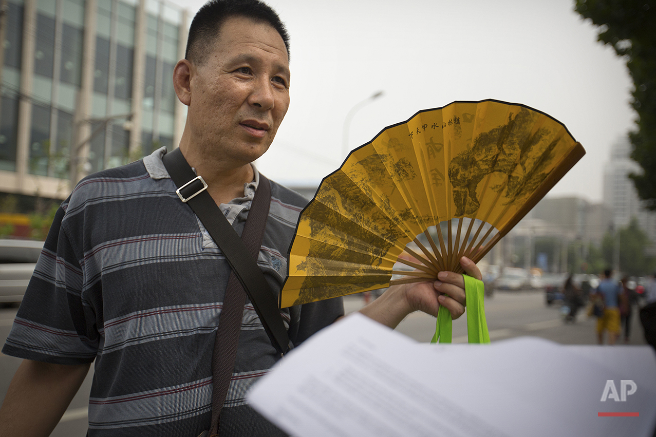  Dr. Men Xuezhi, 54, fans himself as he talks about his views of America while standing outside the U.S. embassy in Beijing on Friday, July 29, 2016. "My impression of Americans is that they uncomplicated. Interpersonal relations among Americans are 