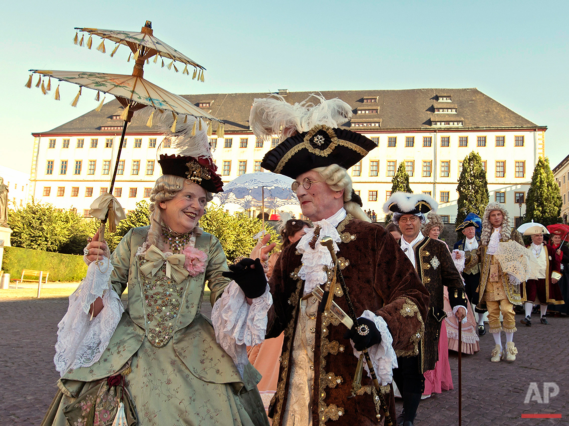  People dressed in Baroque costumes walk in front of the Friedenstein Castle during the opening of the Baroque Festival in Gotha, Germany, Friday, Aug. 26, 2016. The castle is the larges German early Baroque palace complex from the 17th century. (AP 