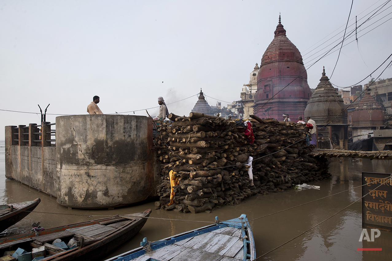  A thin line of smoke rises from burning funeral pyres on a rooftop of a temple at the flooded Manikarnika Ghat in Varanasi, India, Saturday, Aug. 27, 2016. As the mighty Ganges River overflowed its banks this past week following heavy monsoon rains,
