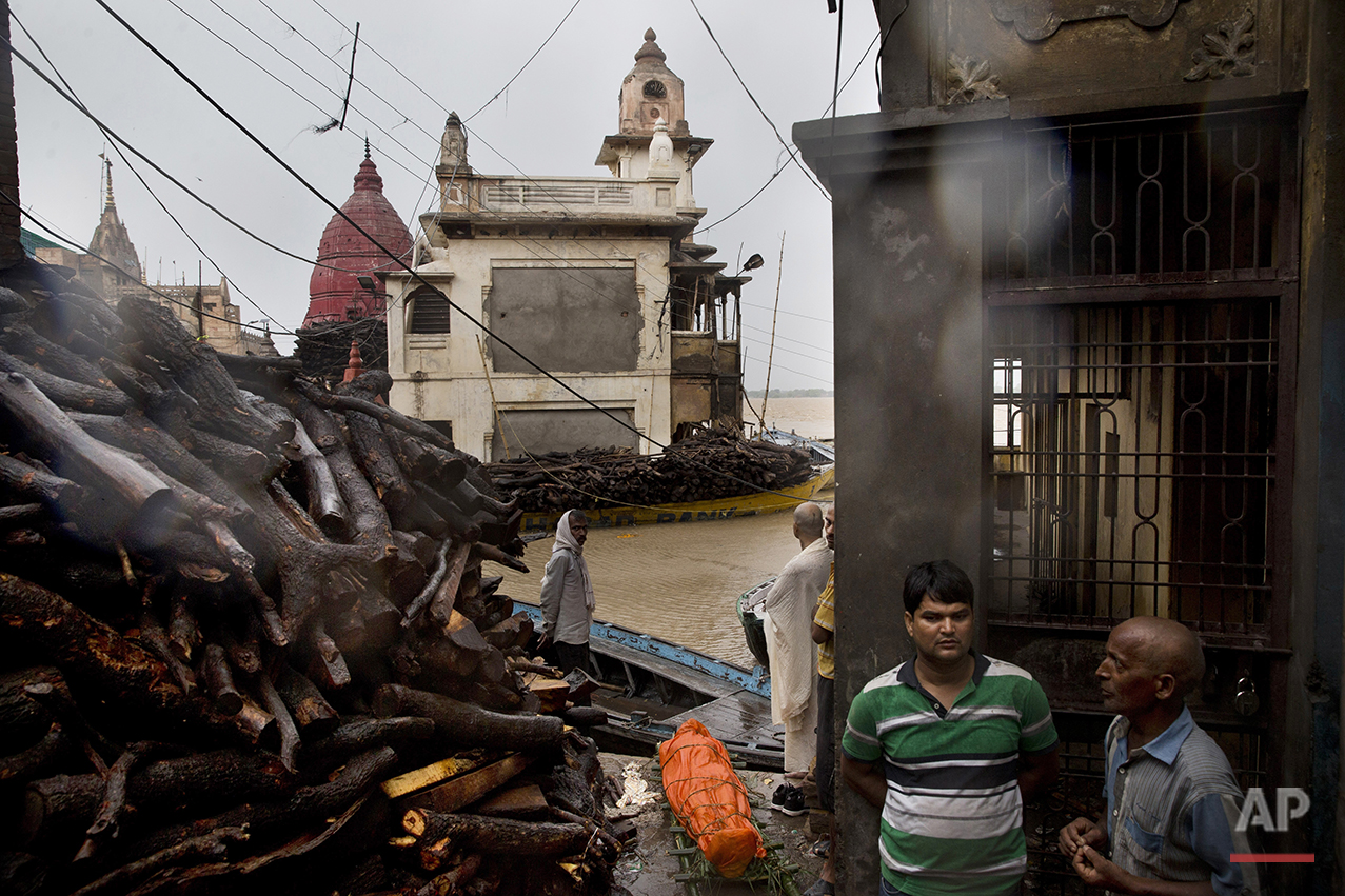  In this Friday, Aug. 26, 2016 photo, a body to be cremated lies on the floor of the Manikarnika Ghat, submerged by the flood waters, in Varanasi, India. As the mighty Ganges River overflowed its banks this past week following heavy monsoon rains, la