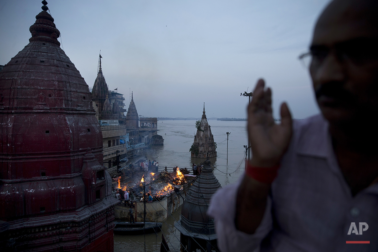  In this Thursday, Aug. 25, 2016 photo, Hindu funerals are performed atop of a Hindu temple at the flooded Manikarnika Ghat in Varanasi, India. As the mighty Ganges River overflowed its banks this past week following heavy monsoon rains, large parts 