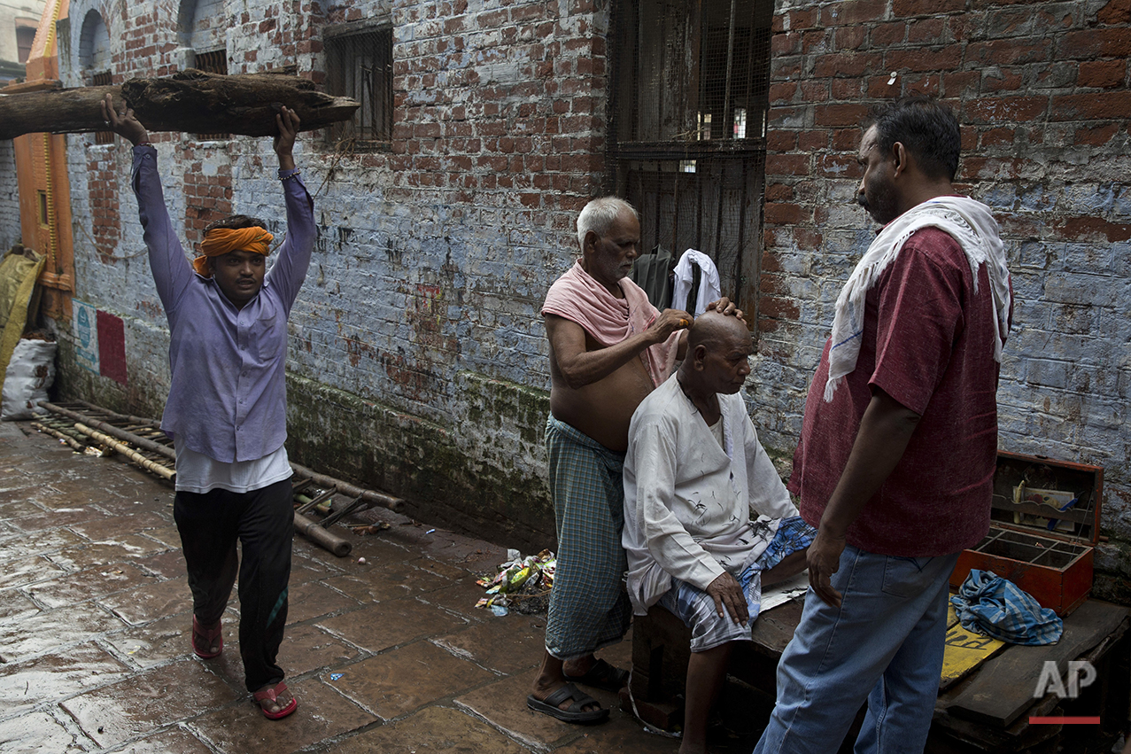  In this Friday, Aug. 26, 2016 photo, a Hindu mourner has his head shaved after attending a funeral service in Varanasi, India.As the mighty Ganges River overflowed its banks this past week following heavy monsoon rains, large parts of the Hindu holy