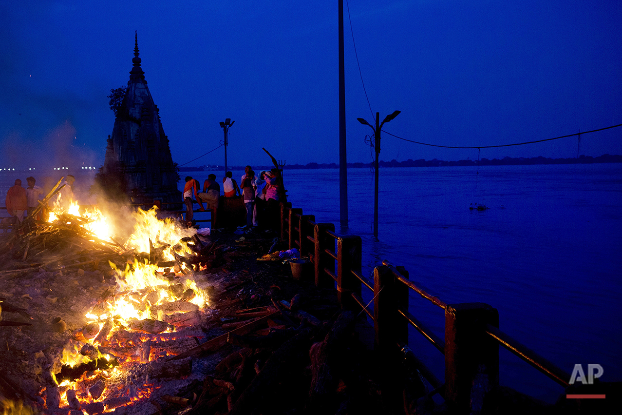  In this Thursday, Aug. 25, 2016 photo, Hindu funerals are performed atop of a Hindu temple at the flooded Manikarnika Ghat in Varanasi, India. As the mighty Ganges River overflowed its banks this past week following heavy monsoon rains, large parts 