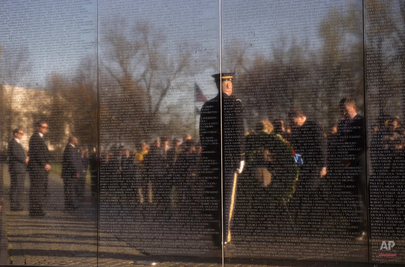  Defense Secretary Ash Carter, right and Veterans Affairs Secretary Robert McDonald are reflected in the Vietnam Memorial Wall as they bow there heads in silence to during a wreath laying ceremony to mark the 50th anniversary of the Vietnam War in Wa