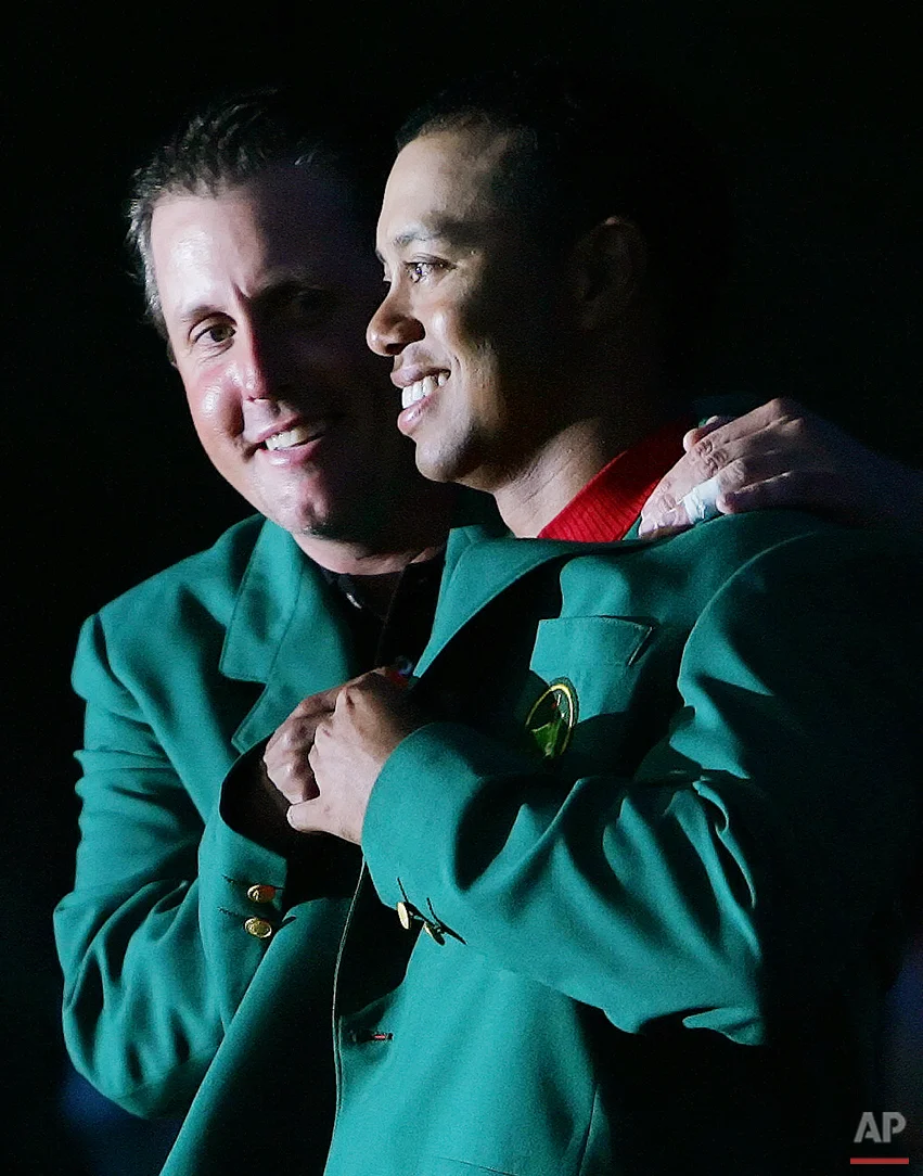 Phil Mickelson, left, last years Masters champion, puts the Green Jacket on Tiger Woods, right, after Woods won the 2005 Masters in a playoff at the Augusta National Golf Club in Augusta, Ga., in this April 10, 2005 photo. (AP Photo/David J. Phillip)