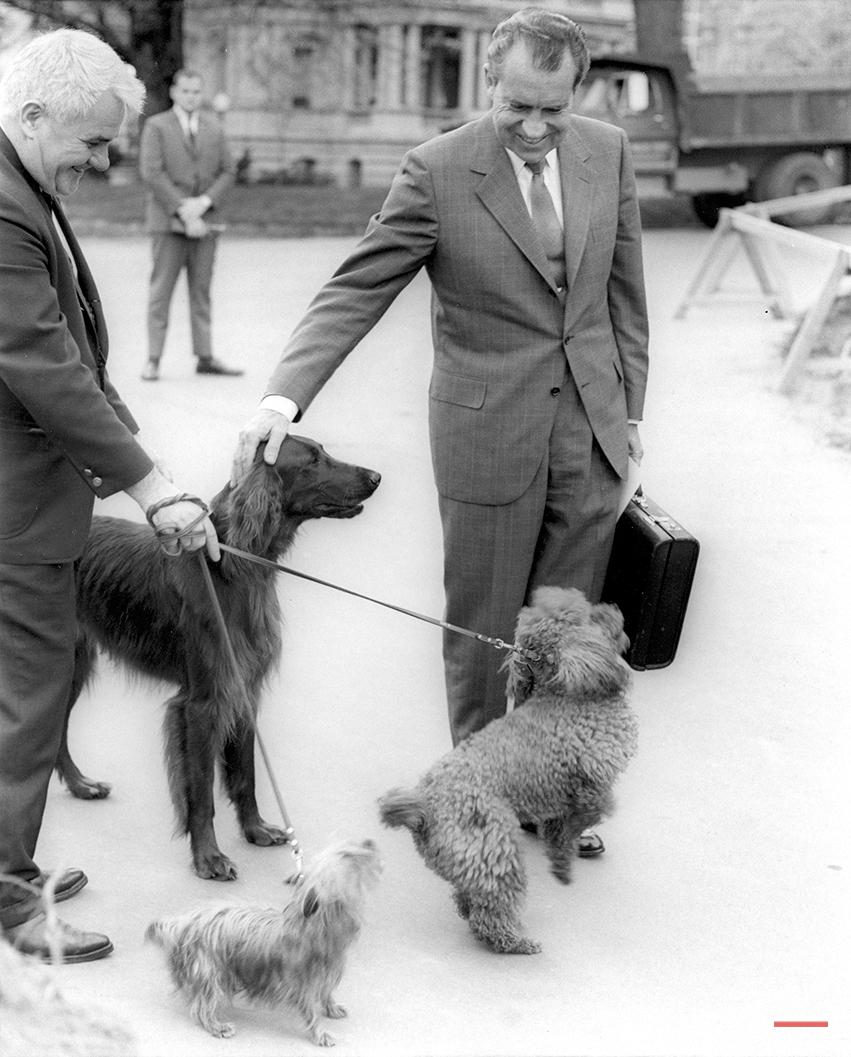 U.S. President Nixon pats the head of his Irish Setter pet King Timahoe as he walks from his office in the Executive Office building to the White House in Washington D.C. on April 30, 1970. White House electrician Traphes Bryant holds back the other first family pets Pasha, a Yorkshire Terrier, and Vickie, a miniature French Poodle. (AP Photo)