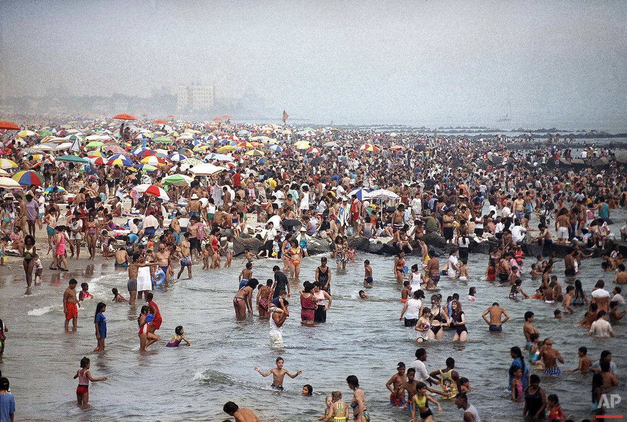 Crowds of people swarm to the beach at Coney Island in Brooklyn on July 21, 1991 in an effort to find relief from temperatures that swarmed over the 100-degree mark in New York City. (AP Photo/Mike Alexander)
