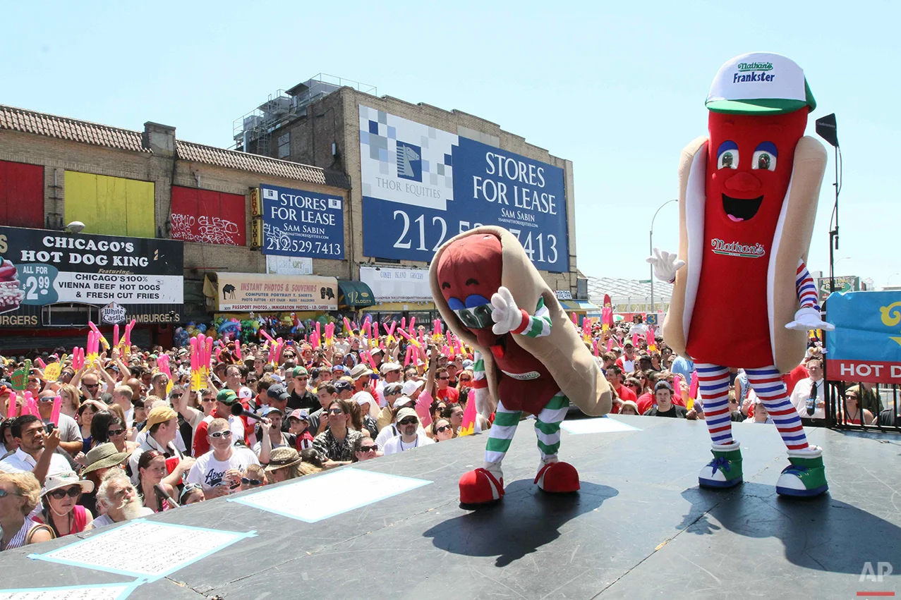 Costumed performers entertain the crowd before the start of Nathan's Hot Dog Eating Contest Sunday July 4, 2010 in the Coney Island section in the Brooklyn borough of New York. (AP Photo/Tina Fineberg)