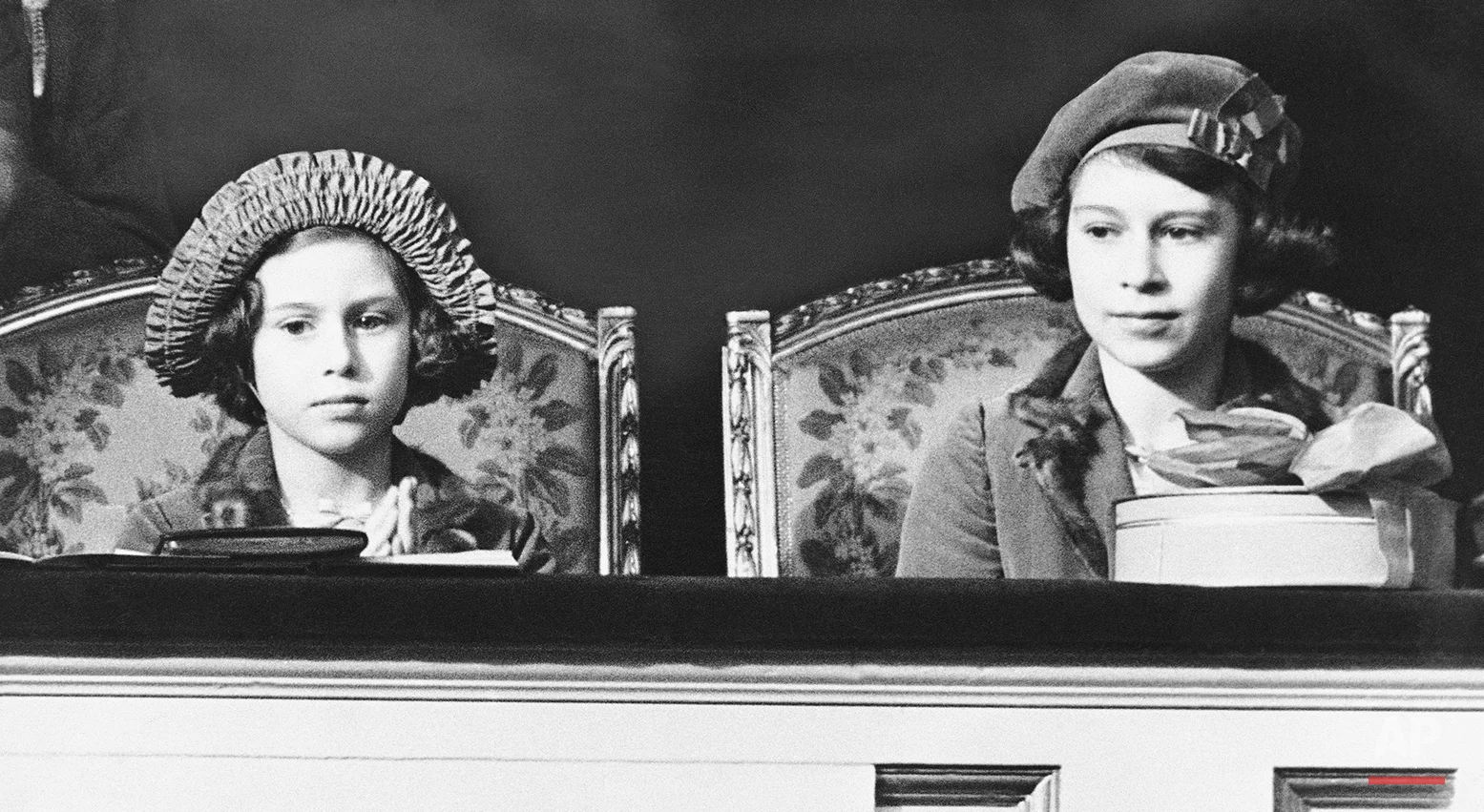 Princess Elizabeth, left, and her younger sister, Princess Margaret Rose, sit in the royal box watching the jumping at the Pony Show, March, 1938, London, England. (AP Photo)