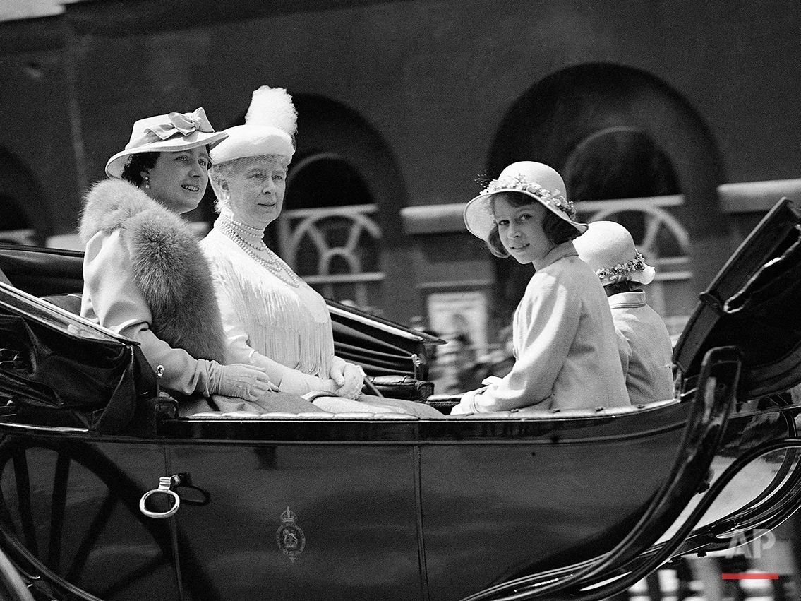 In this June 9, 1937 photo, then Britain's Queen Elizabeth, left, with Queen Mary, second left, and Princesses Elizabeth, nearest camera, and Princess Margaret, obscured right, driving from Buckingham Palace to the Horse Guards Parade for the Trooping of the Colour ceremony, in London. Britain's Queen Elizabeth celebrates her 90th birthday on Thursday, April 21, 2016. (AP Photo/Len Putnam)