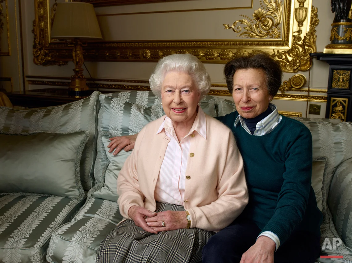 In this official photograph released by Buckingham Palace on Wednesday April 20, 2016 to mark her 90th birthday, Queen Elizabeth II is pictured with her daughter, The Princess Royal, in the White Drawing Room at Windsor Castle in England. (© 2016 Annie Leibovitz via AP) 