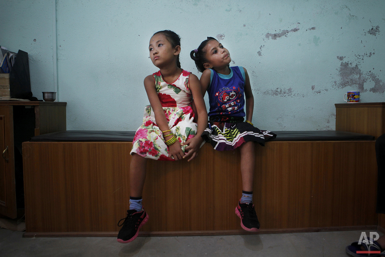  In this Sept. 8, 2015 photo, best of friends Khendo Tamang, left, and Nirmala Pariyar, both 8, wait to be measured for new prosthetic legs in Kathmandu, Nepal. The girls became close friends while in recovery after each one lost a leg in Nepal's mas