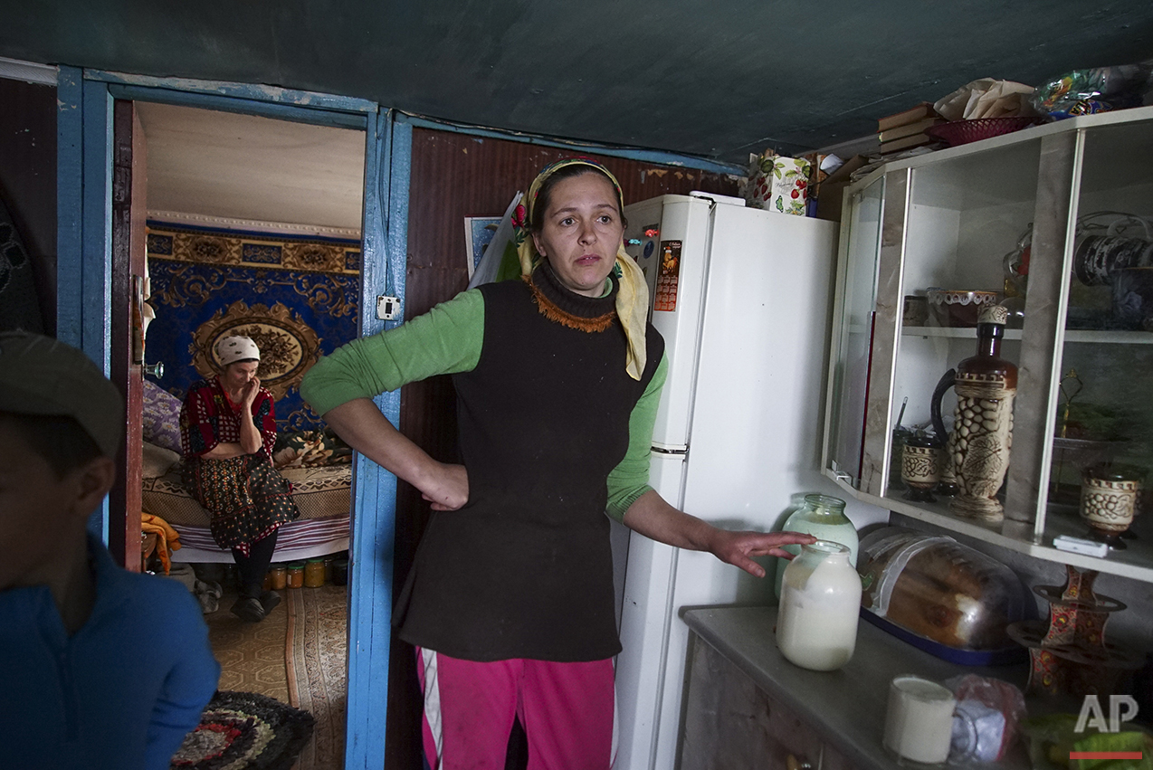  In this photo taken on Tuesday, April  5, 2016, Viktoria Vetrova holds a jar with fresh cow milk, believed to be radioactive, in her house, with her mother Tatiana Vetrova sitting in the back, in Zalyshany, 53 km (32 miles) southwest of the destroye