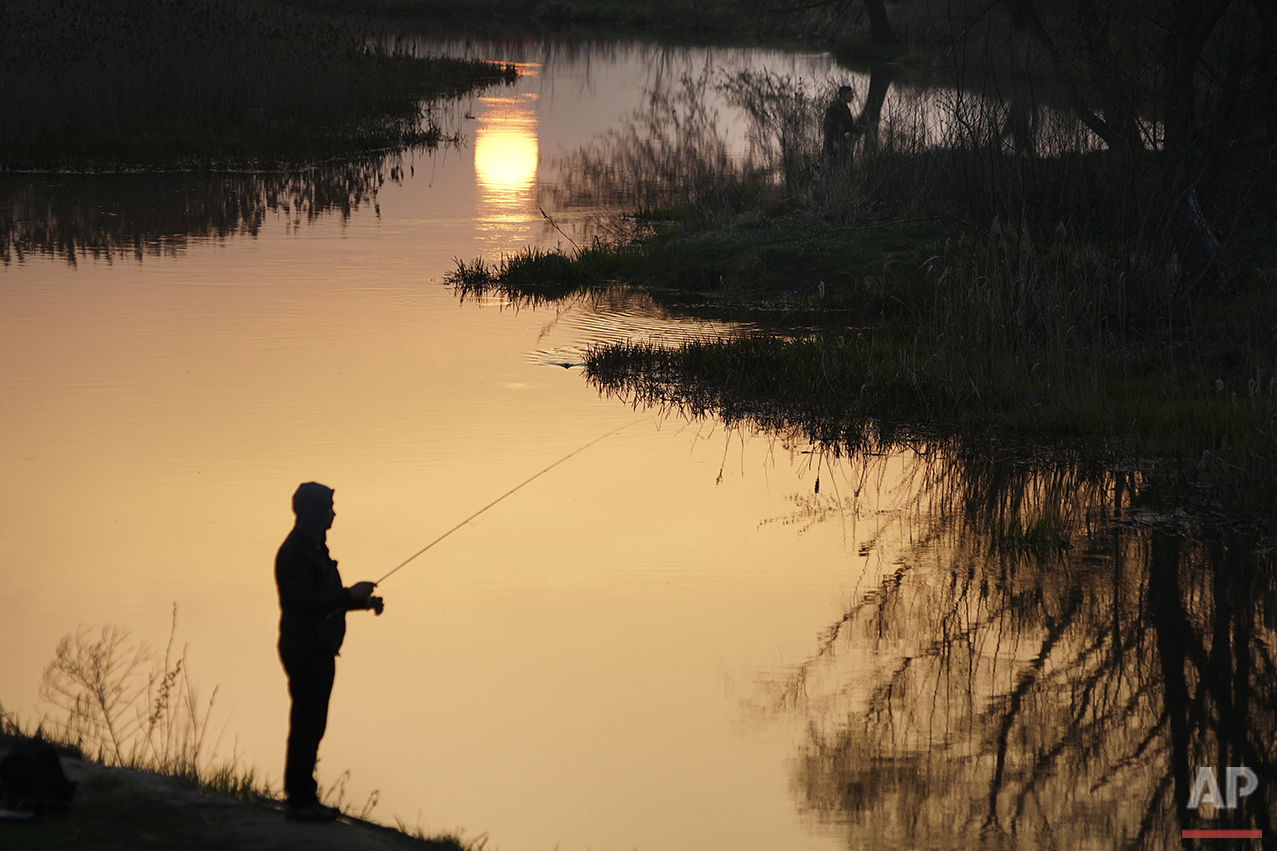  In this photo taken on Thursday, April  7, 2016, a man fishes in a river near Ivankiv, Ukraine. (AP Photo/Mstyslav Chernov) 