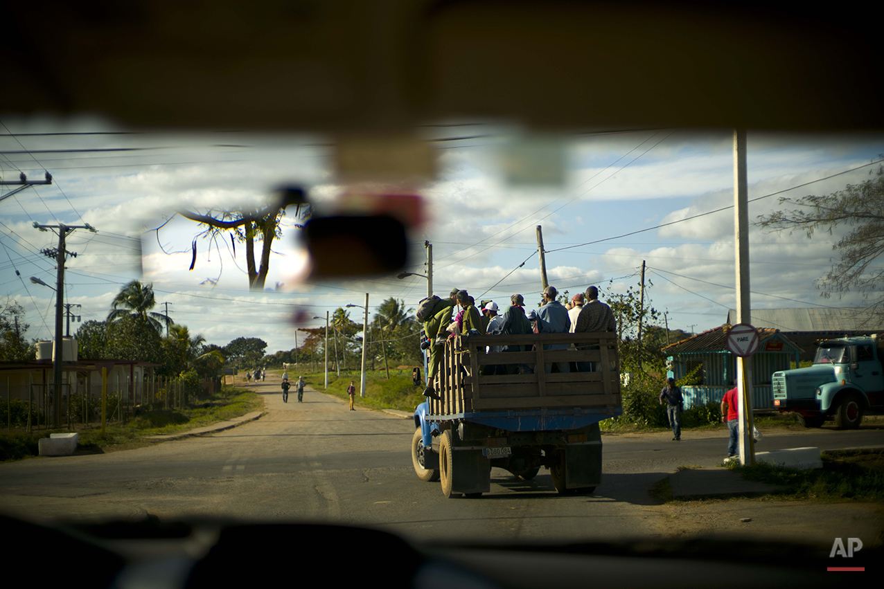  In this Feb. 26, 2016 photo, a soldier climbs up a truck that stopped for him to join residents commuting home after the workday in the province of Pinar del Rio, Cuba, where tobacco farming is the main crop. Despite the flood of visitors since Cuba