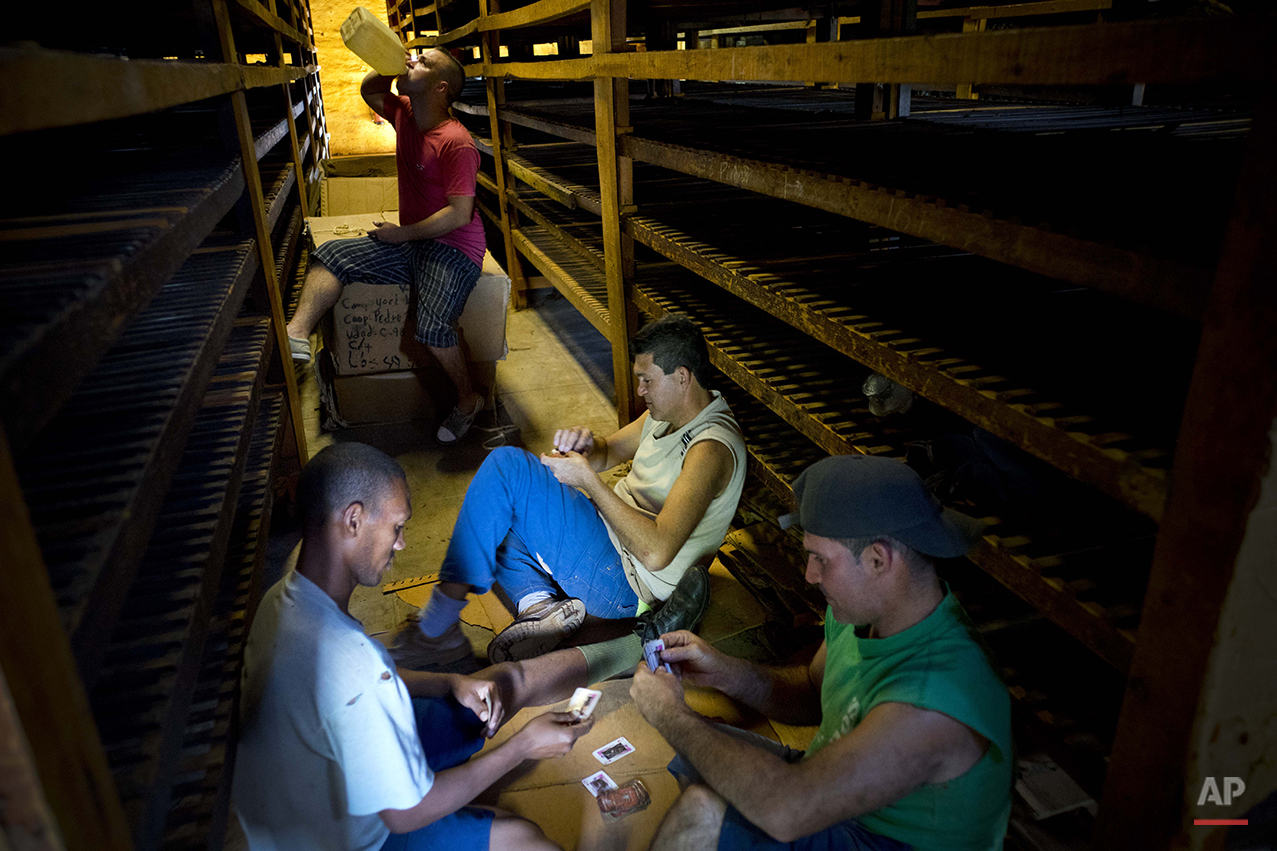  In this March 1, 2016 photo, workers play cards during their lunch break between drying tobacco leaves at a warehouse in the province of Pinar del Rio, Cuba. The leaves are brought here to "breath" after being previously dipped in ammonium and water