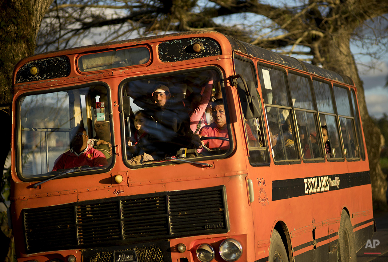  In this Feb. 26, 2016 photo, residents travel in a former school bus to the center of the town of Vinales in the province of Pinar del Rio, Cuba, where tobacco farming is the main crop. Despite the flood of visitors since Cuba and the U.S. reestabli