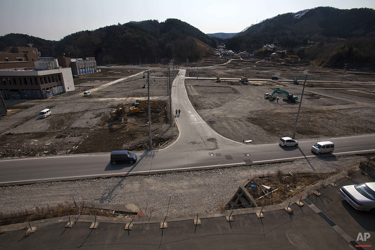  In this Feb. 22, 2012 photo, two officials walk along a street in the tsunami and earthquake destroyed town of Onagawa, Miyagi Prefecture, northern Japan. (AP Photo/David Guttenfelder) 