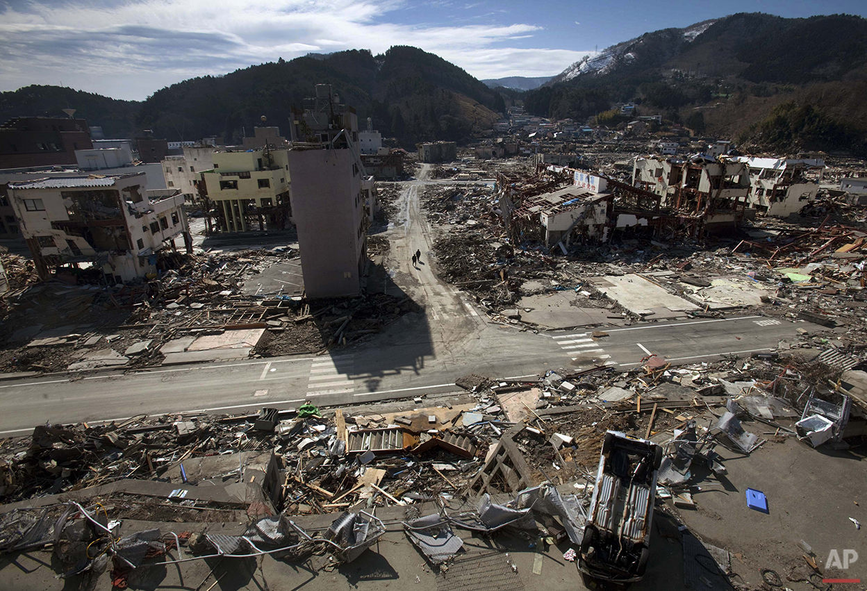  In this March 19, 2011 photo, residents of the tsunami- and earthquake-destroyed town of  Onagawa, Miyagi Prefecture in northeastern Japan walk down an empty street. (AP Photo/David Guttenfelder) 