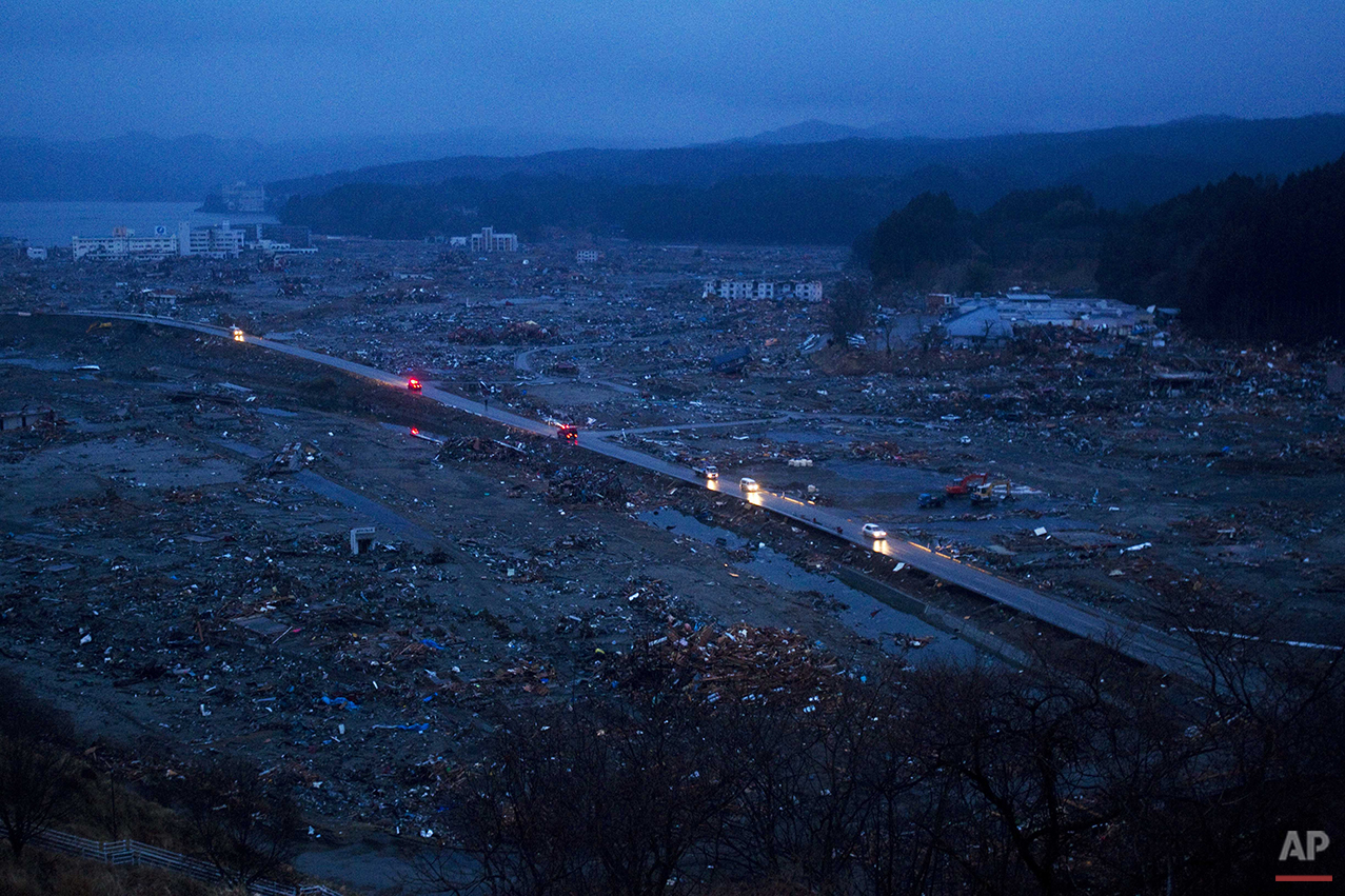  In this March 15, 2011 photo, vehicles pass through the ruins of the leveled city of Minamisanriku, Miyagi Prefecture, northeastern Japan. (AP Photo/David Guttenfelder) 