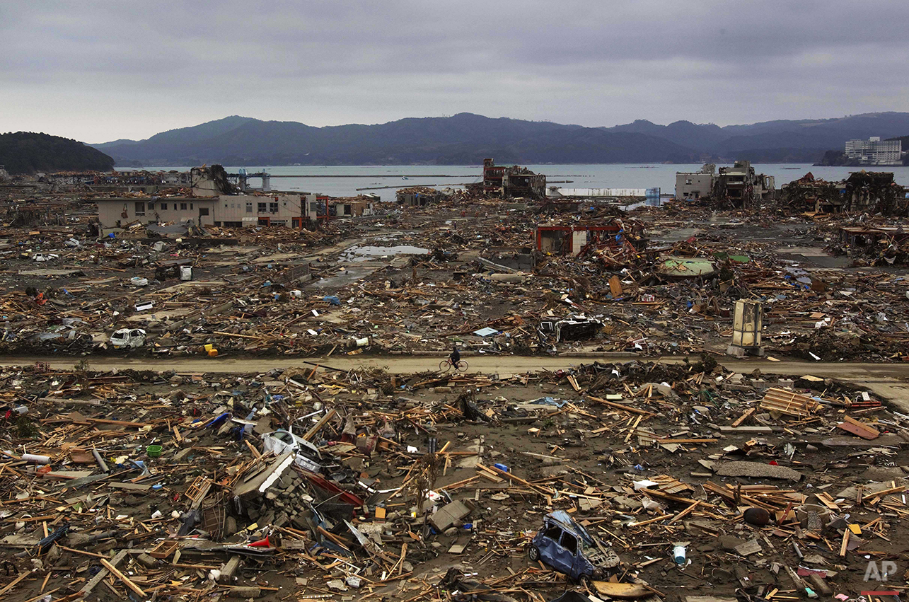  In this March 15, 2011 photo, a Japanese survivor of the earthquake and tsunami rides his bicycle through the leveled city of Minamisanriku, Miyagi Prefecture, northeastern Japan, four days after the disaster. (AP Photo/David Guttenfelder) 