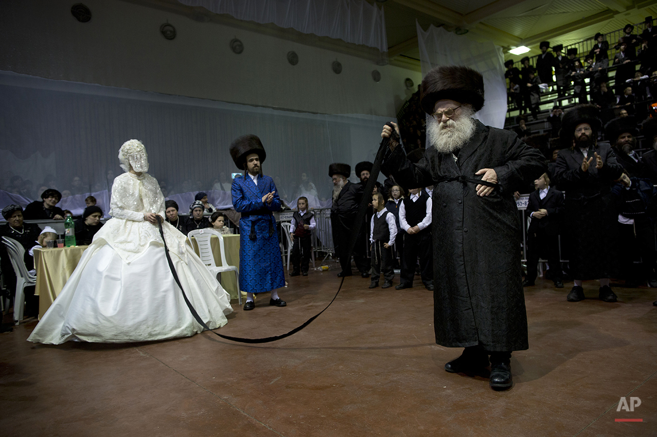  An ultra-Orthodox Jewish bride enters to the men's section of the wedding, to fulfill the Mitzvah tantz, in which family members and honored rabbis are invited to dance in front of the bride, often holding a gartel, and then dancing with the groom, 