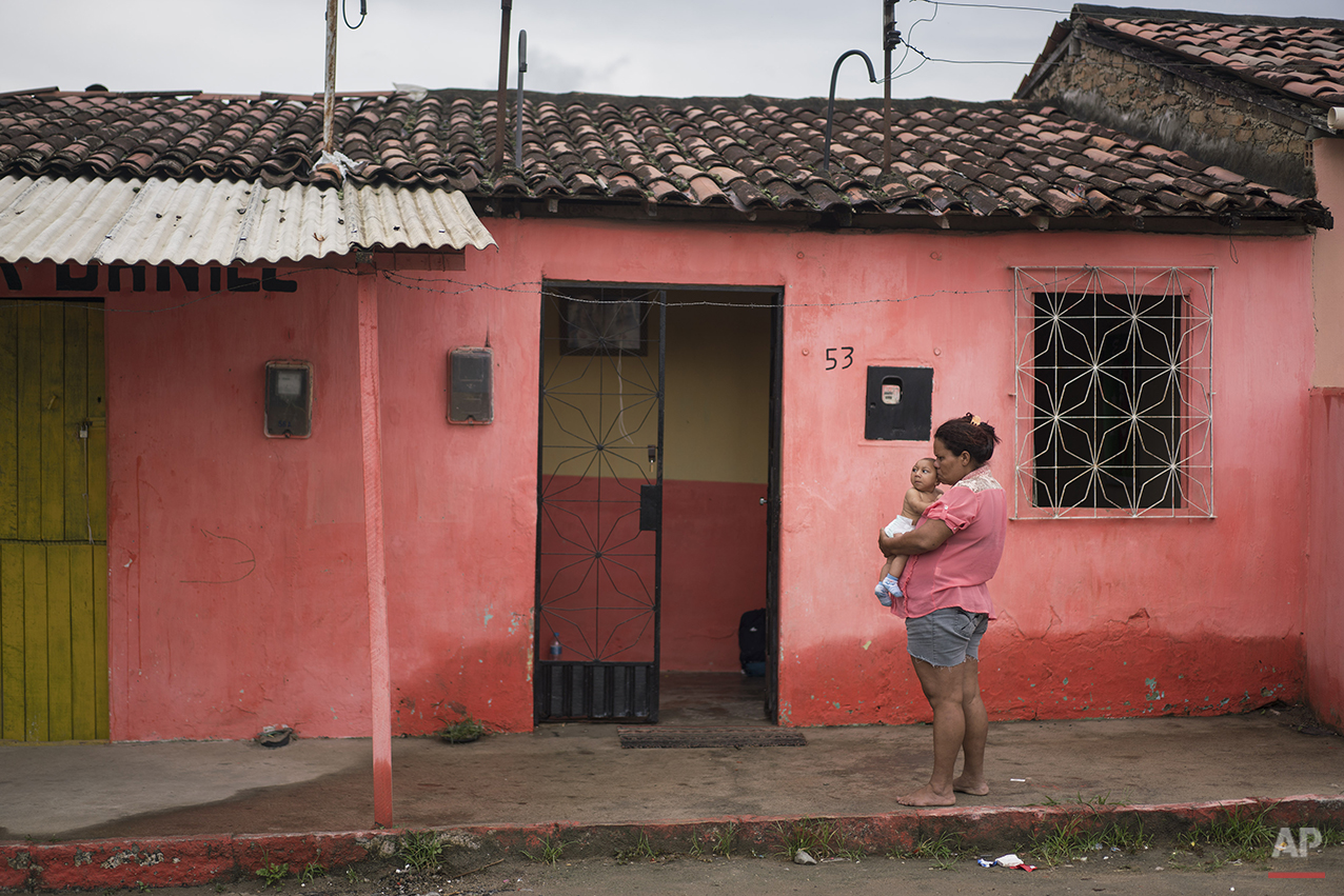  In this Jan. 30, 2016 photo, Solange Ferreira holds Jose Wesley outside their house in Bonito, Pernambuco state, Brazil. Ferreira has moved to the town of Bonito, leaving her husband in their old village. She said she wanted closer to the city of Re