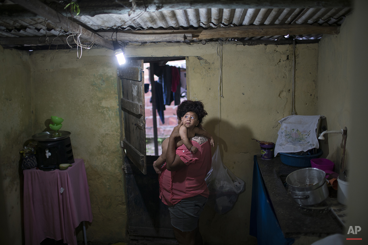  In this Jan. 30, 2016 photo, Solange Ferreira carries her son Jose Wesley at their house in Bonito, Pernambuco state, Brazil. Jose suffers from microcephaly, or an abnormally small head that is a sign of severe disabilities and a truncated life-expe