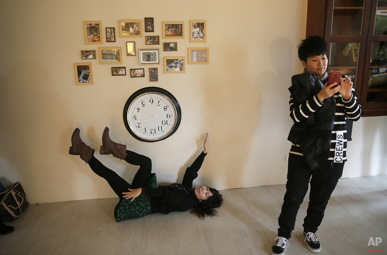  A visitor poses for a photo inside an upside-down house created by a group of Taiwanese architects at the Huashan Creative Park in Taipei, Taiwan, Tuesday, Feb. 23, 2016. With a build price of $600,000 and over 300 square meters (3,230 square feet) 