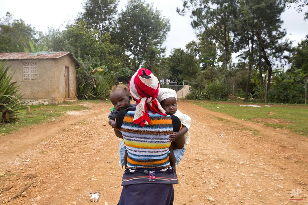  In this Feb. 15, 2016 photo, Carole Joseph holds her toddler twins, Angelo, left, and Angela, after visiting a local health center to examine her children for signs of malnutrition, in Oriani, Haiti. The 28-year-old mother of four, is among roughly 