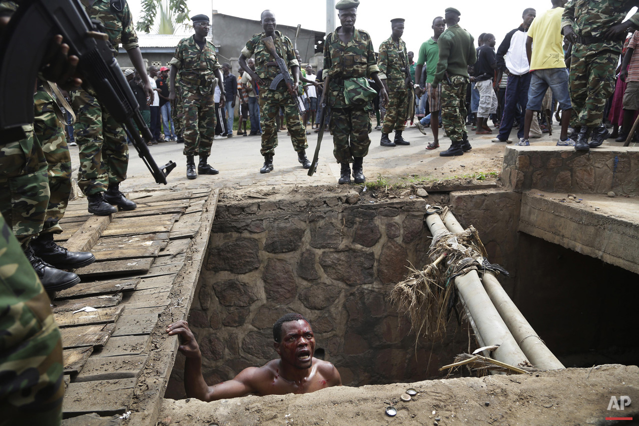  Jean Claude Niyonzima, a suspected member of the ruling party's Imbonerakure youth militia, pleads with soldiers to protect him from a mob of demonstrators after he emerged from hiding in a sewer in the Cibitoke district of Bujumbura, Burundi on Thu