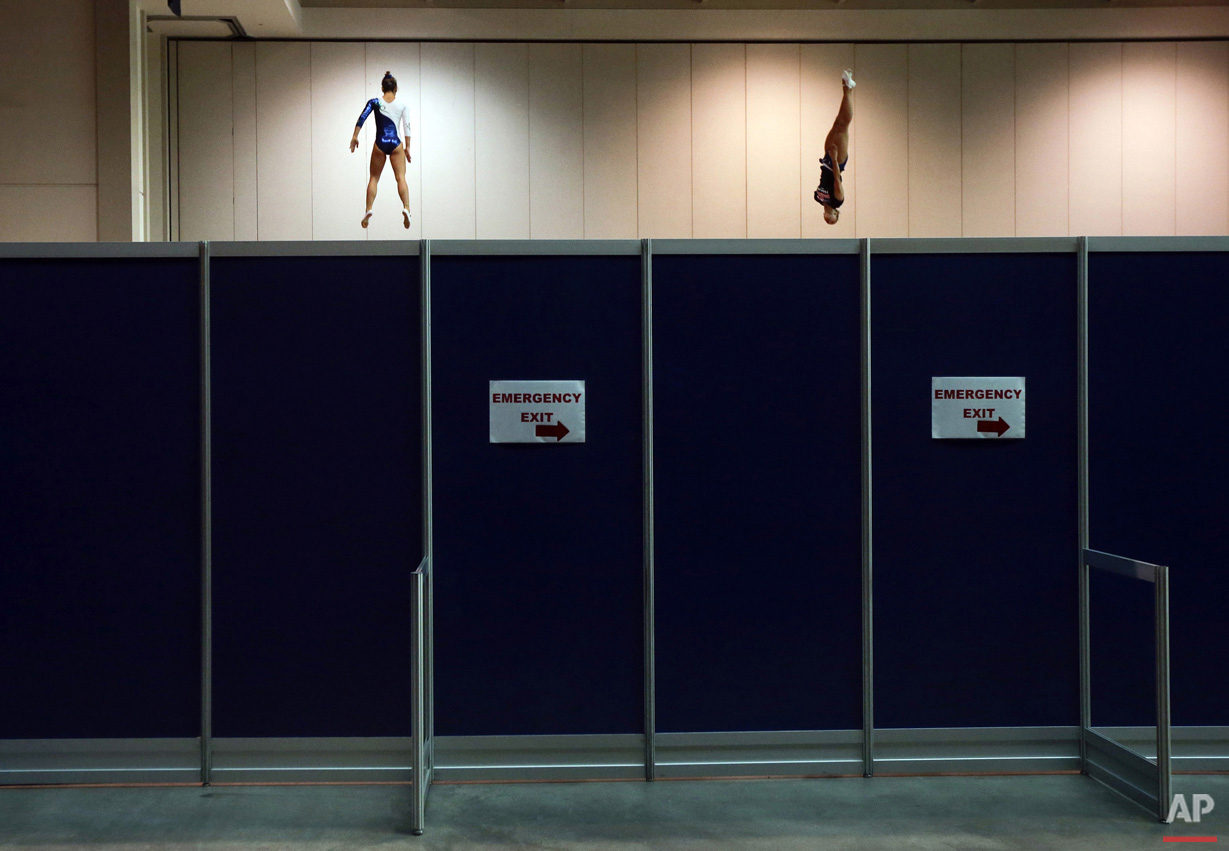  Brazil's Camilla Lopes, left, and the United States' Charlotte Drury warm up on trampolines behind a partition before women's trampoline competition at the Pan Am Games in Toronto, Sunday, July 19, 2015.  