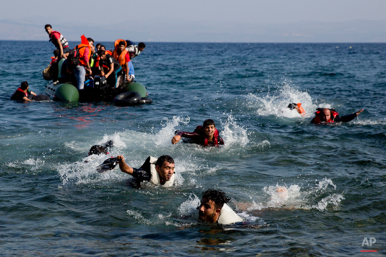  Migrant whose boat stalled at see while crossing from Turkey to Greece swim to approach a shore of the island of Lesbos, Greece, on Sunday, Sept. 20, 2015. A boat with 46 migrants or refugees has sunk Sunday in Greece and the coast guard says it is 