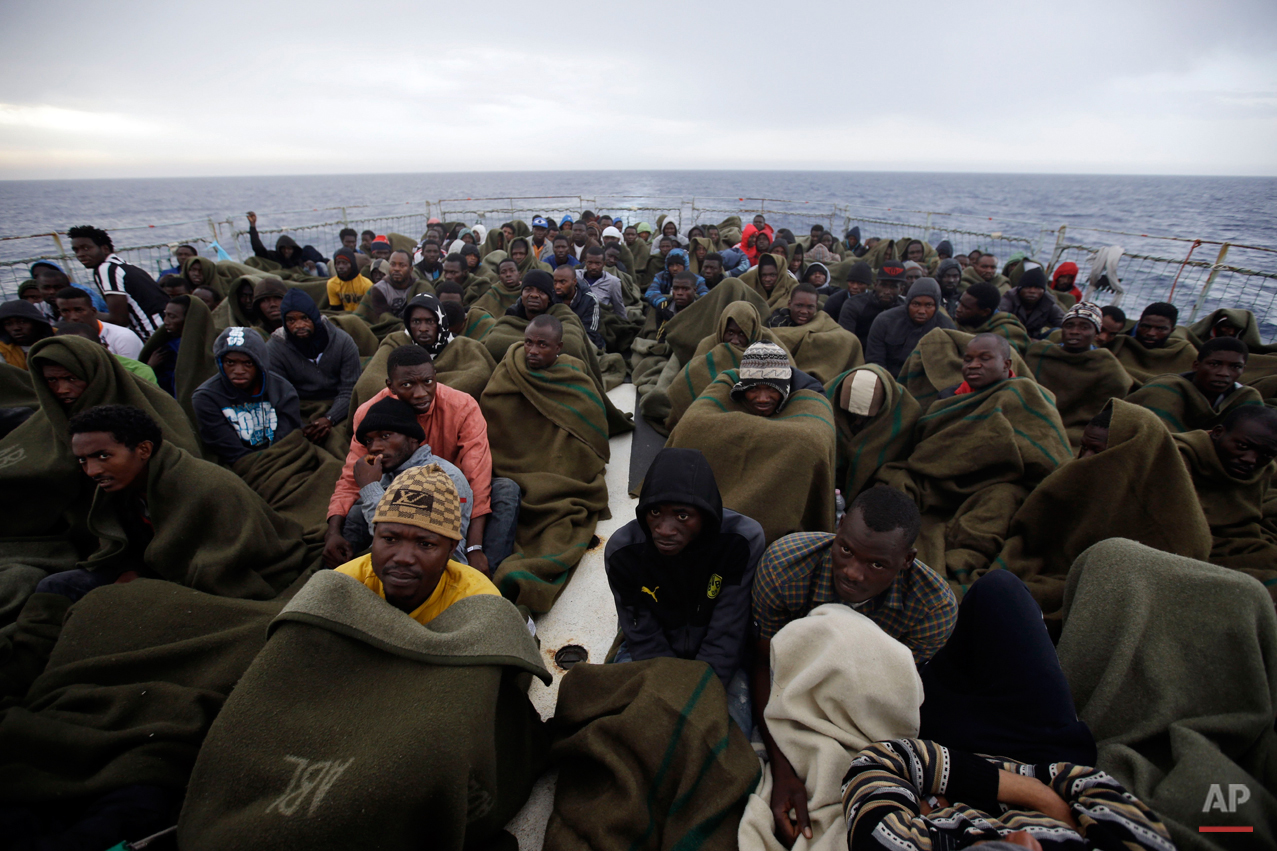  Migrants sit on the deck of the Belgian Navy vessel Godetia after they were saved at sea during a search and rescue mission in the Mediterranean Sea off the Libyan coasts, Wednesday, June 24, 2015. Hundreds of migrants were rescued by the Godetia, w