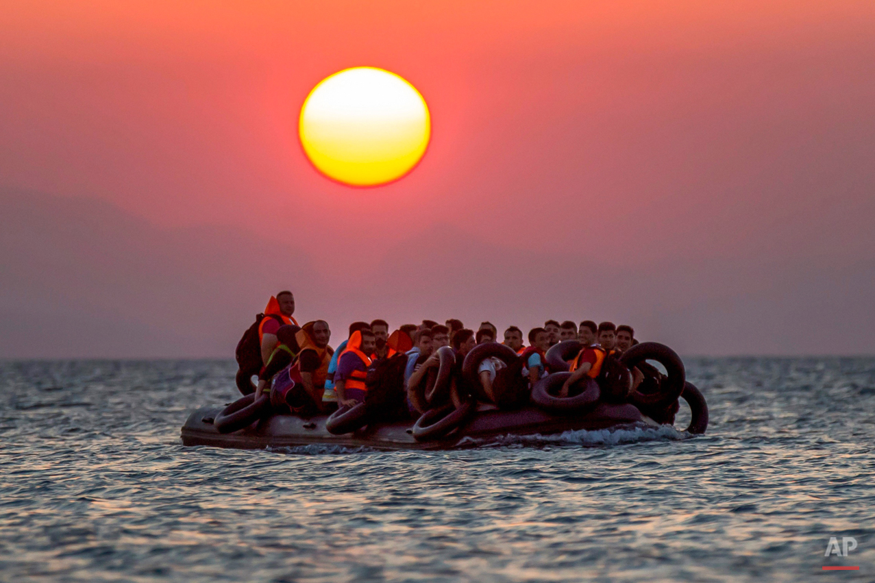  Migrants on a dinghy arrives at the southeastern island of Kos, Greece, after crossing from Turkey, Thursday, Aug. 13, 2015. Greece has become the main gateway to Europe for tens of thousands of refugees and economic migrants, mainly Syrians fleeing