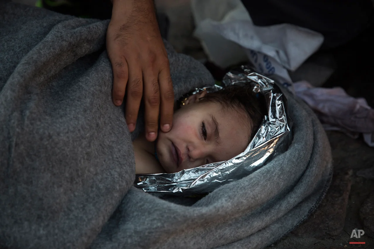 Paramedics and doctors care for a baby girl after a boat with refugees and migrants sunk while was crossing the Aegean sea from Turkey to the Greek island of Lesbos on Wednesday, Oct. 28, 2015. (AP Photo/Santi Palacios)