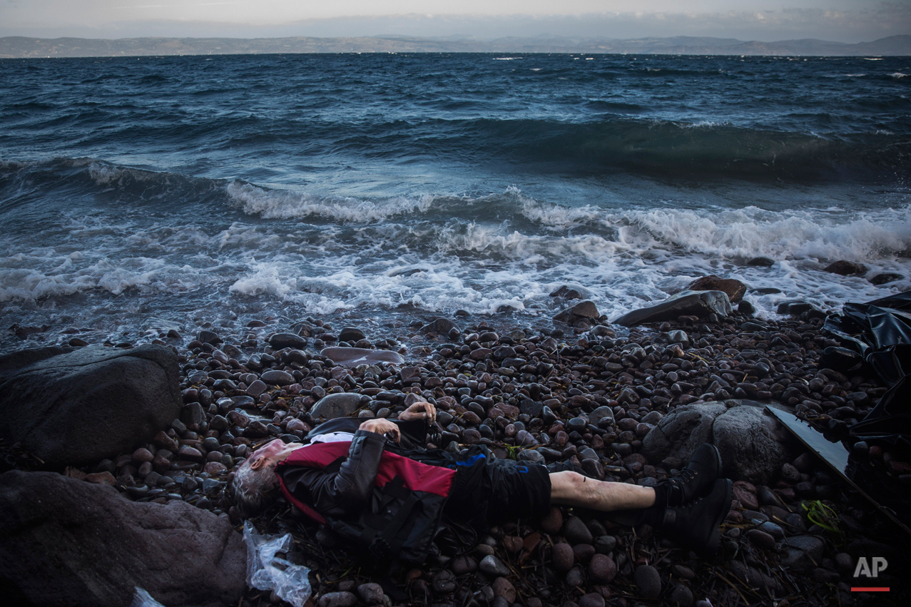  The lifeless body of an elderly unidentified man is seen on the beach after washing up on the shoreline at the village of Skala, on the Greek island of Lesbos, on Sunday, Nov. 1, 2015. Authorities recovered more bodies on Lesbos and the Greek island
