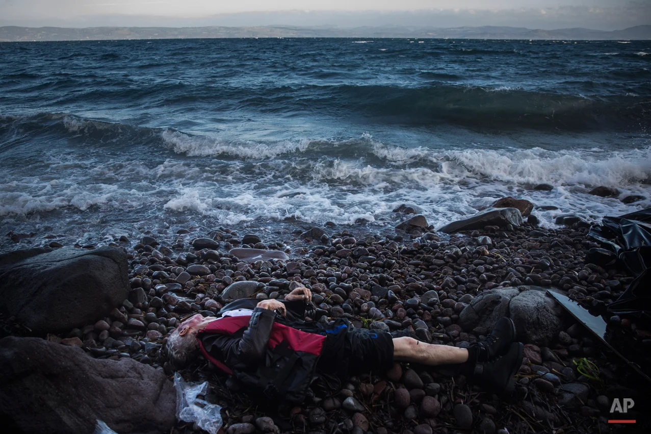 The lifeless body of an elderly unidentified man is seen on the beach after washing up on the shoreline at the village of Skala, on the Greek island of Lesbos, on Sunday, Nov. 1, 2015. Authorities recovered more bodies on Lesbos and the Greek island of Samos Sunday as thousands continue to cross from the nearby coast of Turkey despite worsening weather. Greece is pressing the European Union for additional support for their massive daily search and rescue operations. (AP Photo/Santi Palacios)