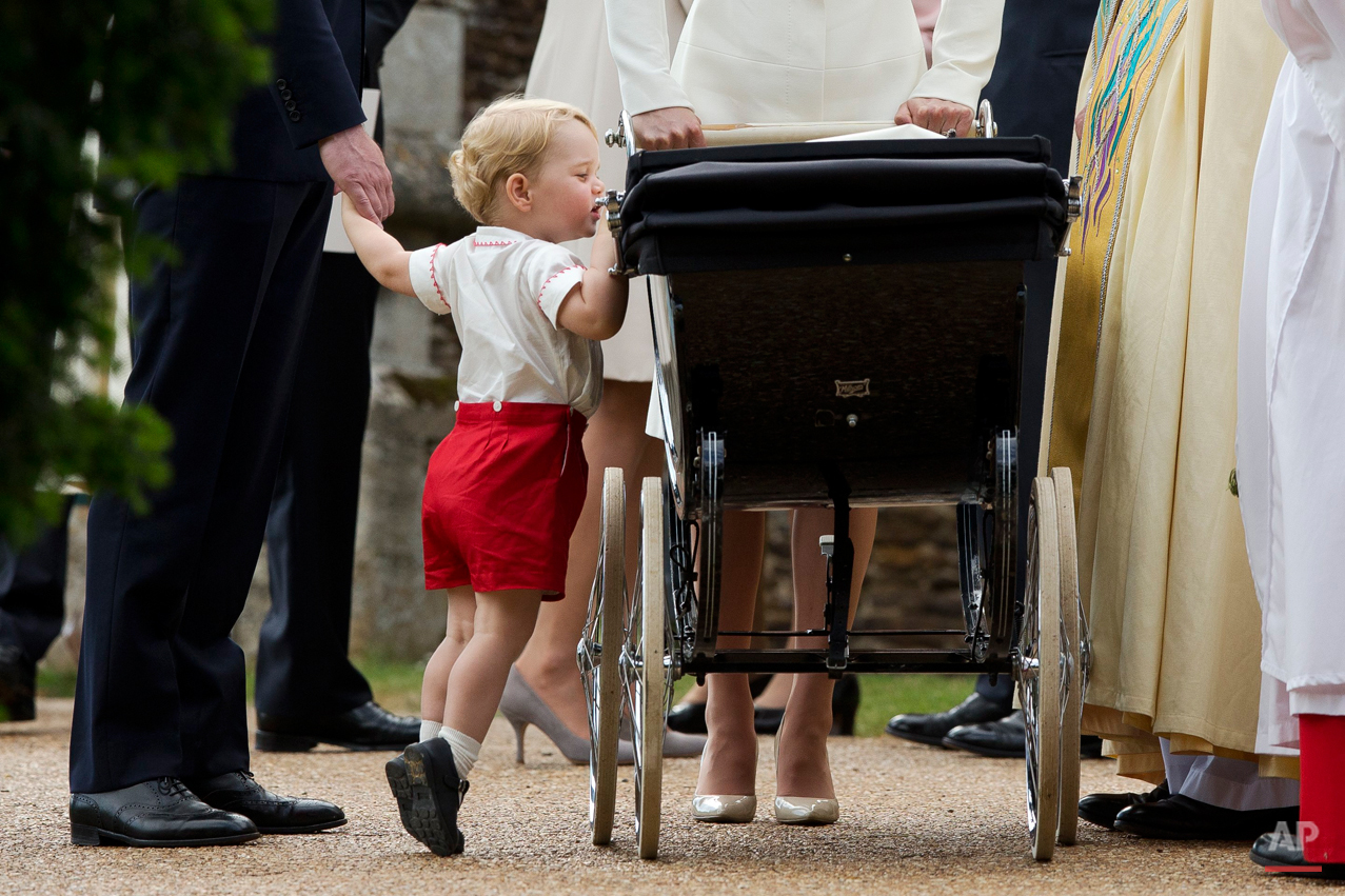  Britain's Prince George gets up on tip-toes to peek into the pram of his sister Princess Charlotte flanked by his parents Prince William and Kate the Duchess of Cambridge as they leave after Charlotte's Christening at St. Mary Magdalene Church in Sa