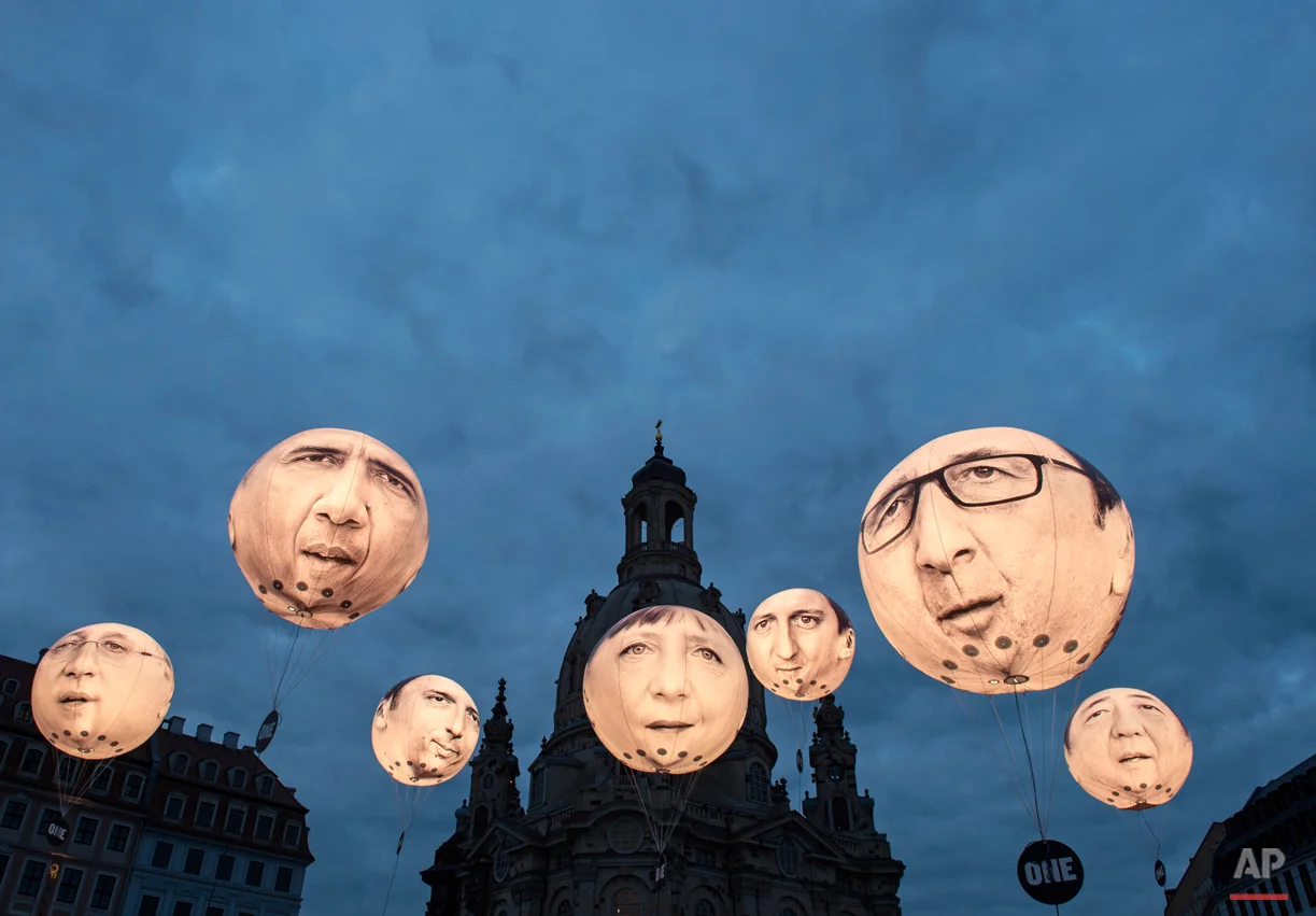 Activists of the international campaigning and advocacy organisation ONE install illuminated balloons with portraits of the G7 heads of state in front of the Frauenkirche cathedral (Church of Our Lady) prior the G7 Finance Ministers meeting in Dresden, eastern Germany, Wednesday, May 27, 2015. (AP Photo/Jens Meyer)