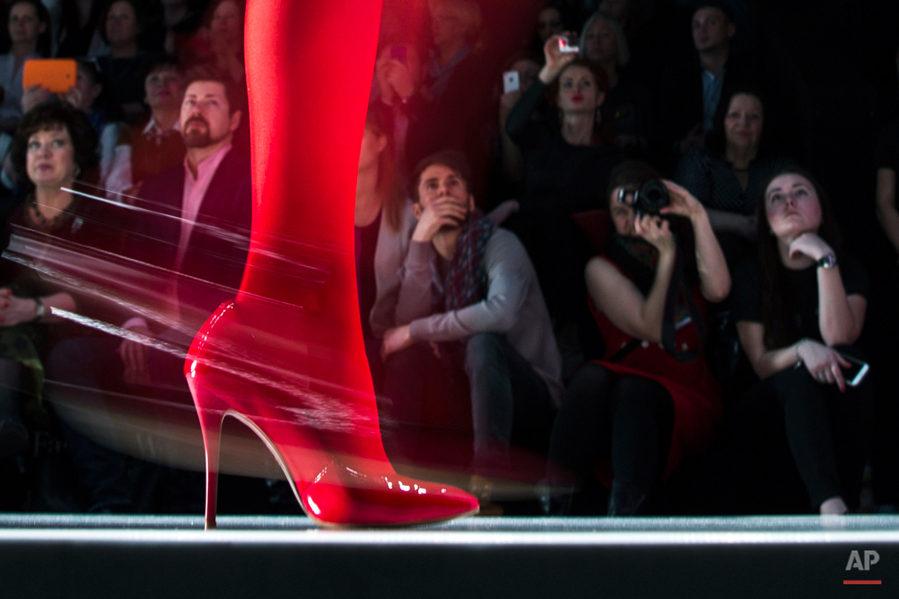  Spectators watch as a model displays a creation by Russian designer Slava Zaitsev during Fashion Week, in Moscow, Russia, Friday, March 27, 2015. (AP Photo/Pavel Golovkin) 