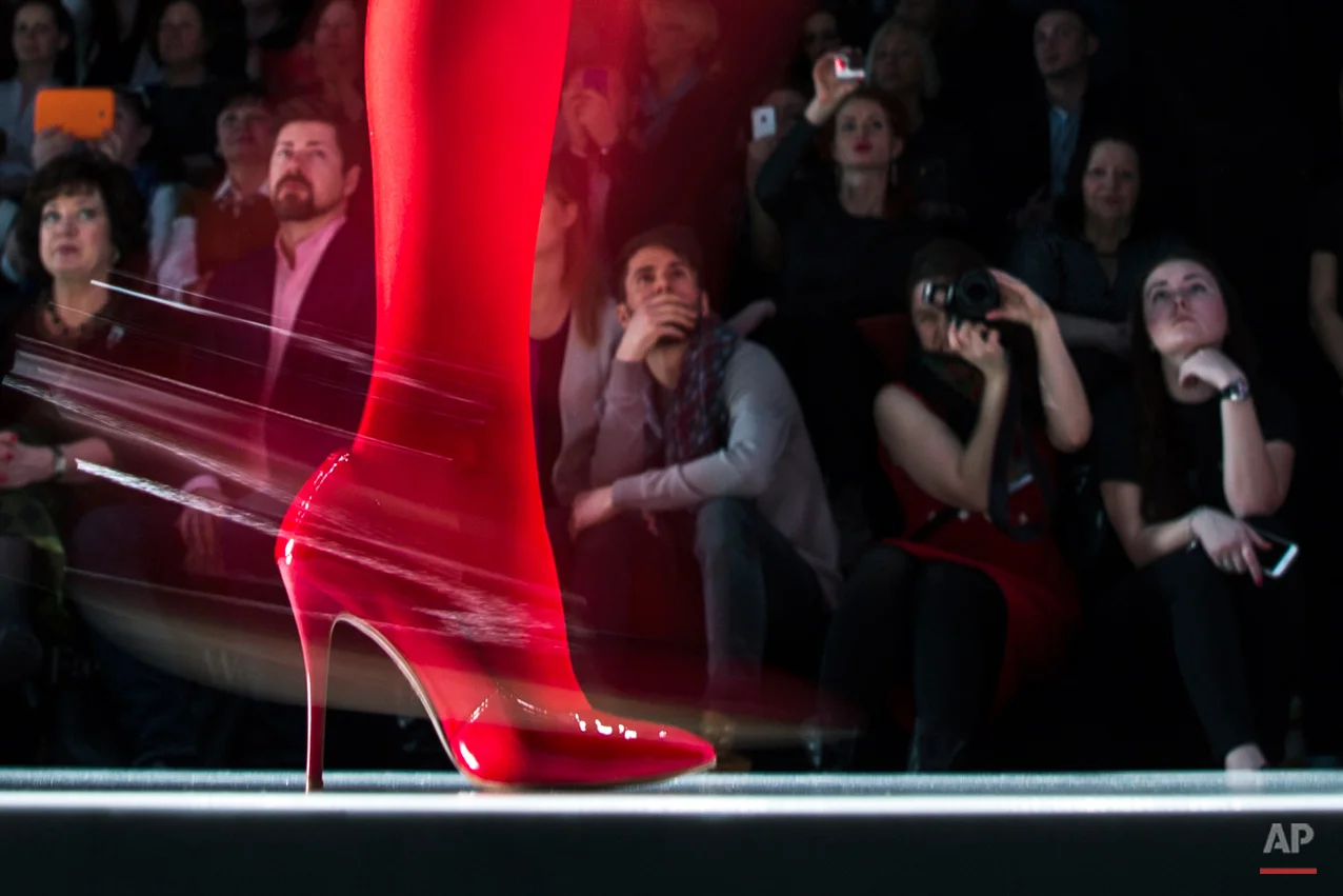 Spectators watch as a model displays a creation by Russian designer Slava Zaitsev during Fashion Week, in Moscow, Russia, Friday, March 27, 2015. (AP Photo/Pavel Golovkin)